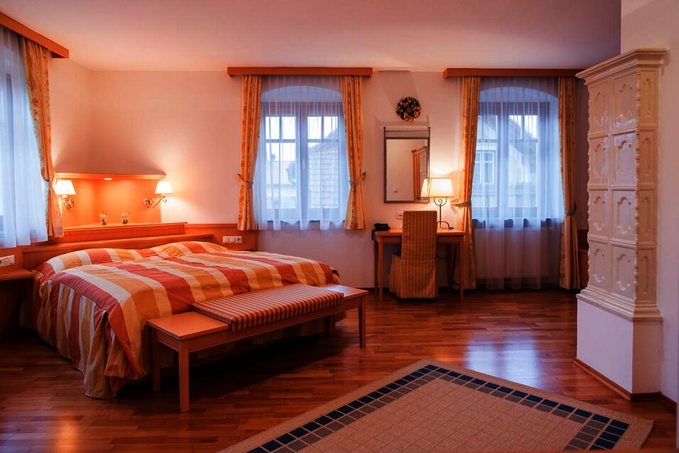 Innenaufnahme der Landhaus-Suite mit Doppelbett und Kamin