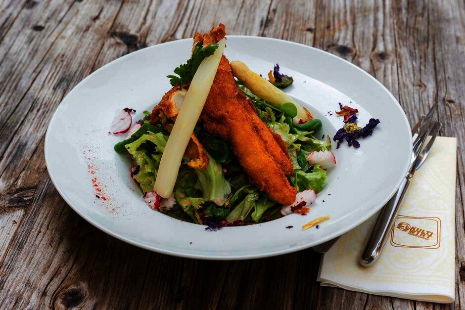 Salat mit gebackenem Huhn und Spargel in einer runden Salatschüssel angerichtet