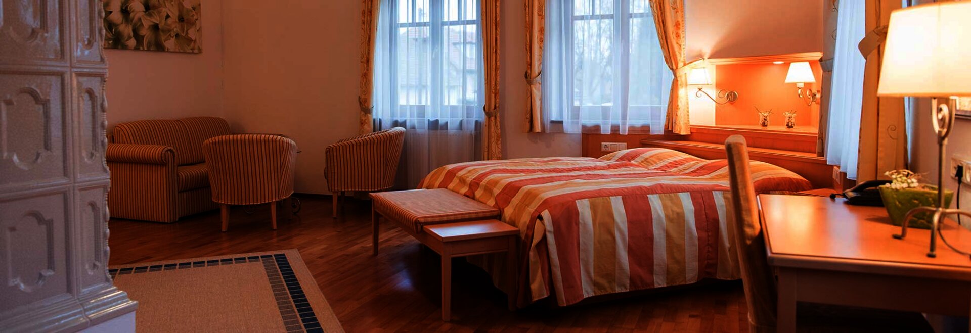 Zimmer in einer Pension mit Doppelbett, Couch und Kamin