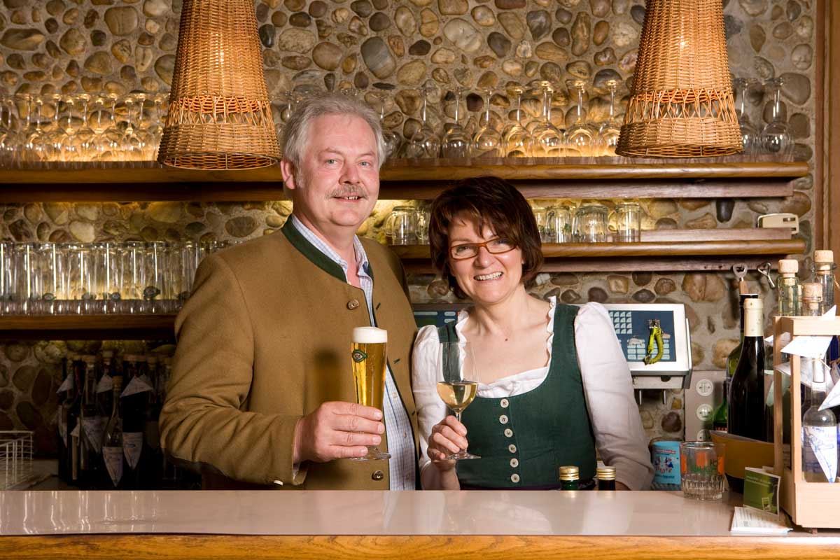 Foto von Karl und Paula Langmayr, mit Getränken in der Hand hinter einer Bar stehend